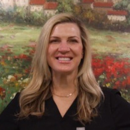 Woman smiling at camera with flower garden background for Riverside Dental